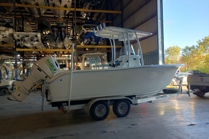 The Image of 2017 Seapro 219 boat on trailer in storage facility with Suzuki outboard motor. - 0
