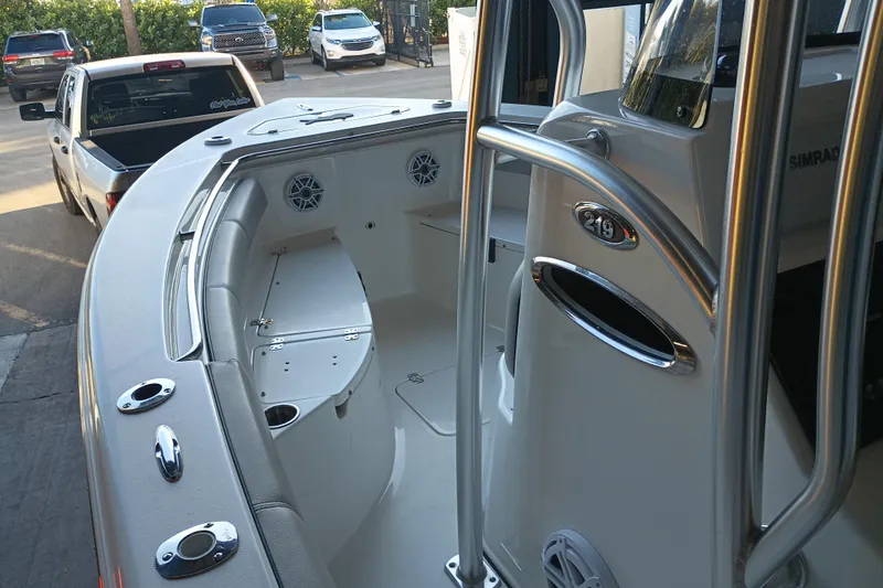 Slide: The Image of 2017 Seapro 219 boat interior with seating and storage, parked near vehicles. - 11