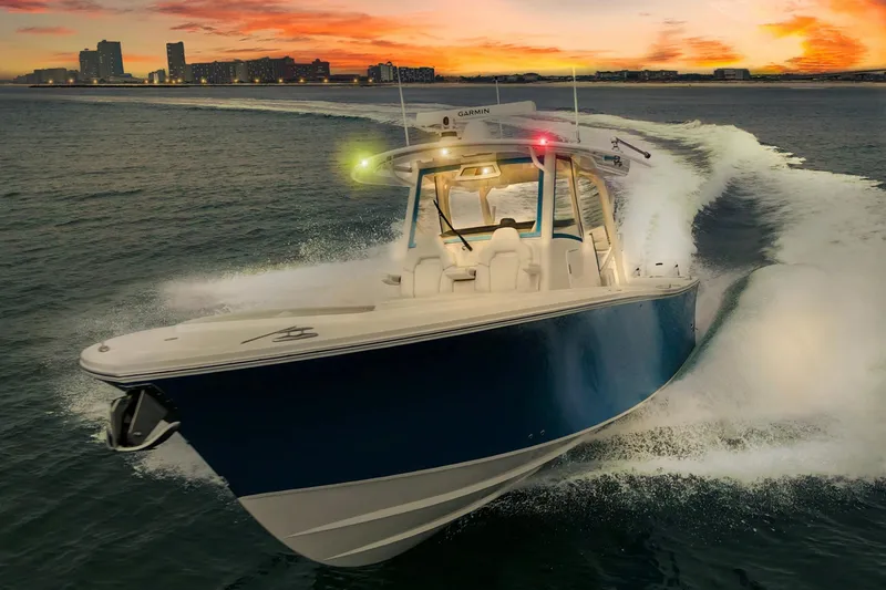 The Image of 2024 Regulator 37 boat cruising at sunset with city skyline in background. - 0