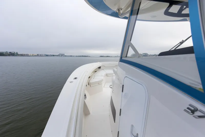 Slide: The Image of 2024 Regulator 37 boat on calm water, showcasing sleek design and spacious deck. - 11