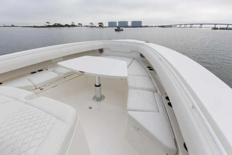 Slide: The Image of 2024 Regulator 37 boat interior with white seating and table on calm water. - 16