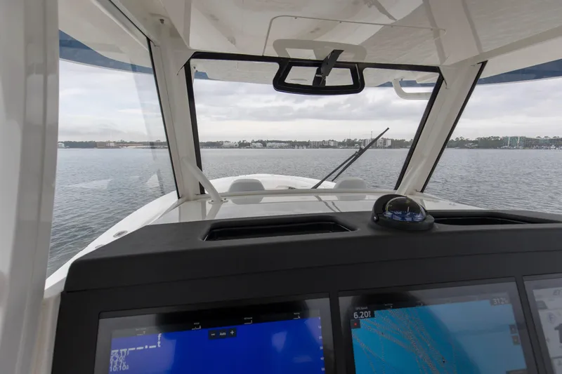 Slide: The Image of 2024 Regulator 37 boat cockpit view with navigation screens and water scenery. - 24