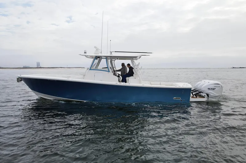 Slide: The Image of 2024 Regulator 37 boat on water, featuring sleek blue hull and twin Yamaha engines. - 30