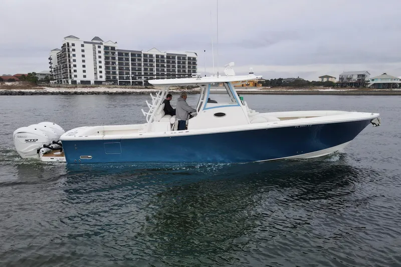 Slide: The Image of 2024 Regulator 37 boat cruising on water near coastal buildings. - 34