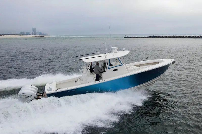 Slide: The Image of 2024 Regulator 37 boat cruising on open water with twin Yamaha engines. - 36