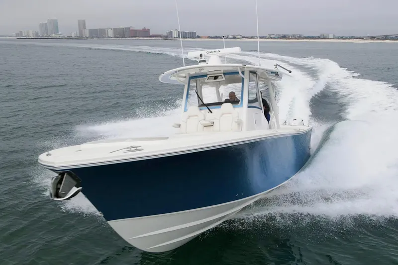 Slide: The Image of 2024 Regulator 37 boat cruising on open water with city skyline in background. - 40