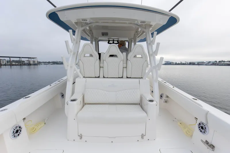 Slide: The Image of 2024 Regulator 37 boat interior with white seating and helm, on calm water. - 5