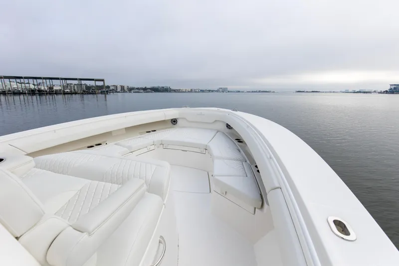 Slide: The Image of 2024 Regulator 37 boat with white seating, docked on calm water. - 7