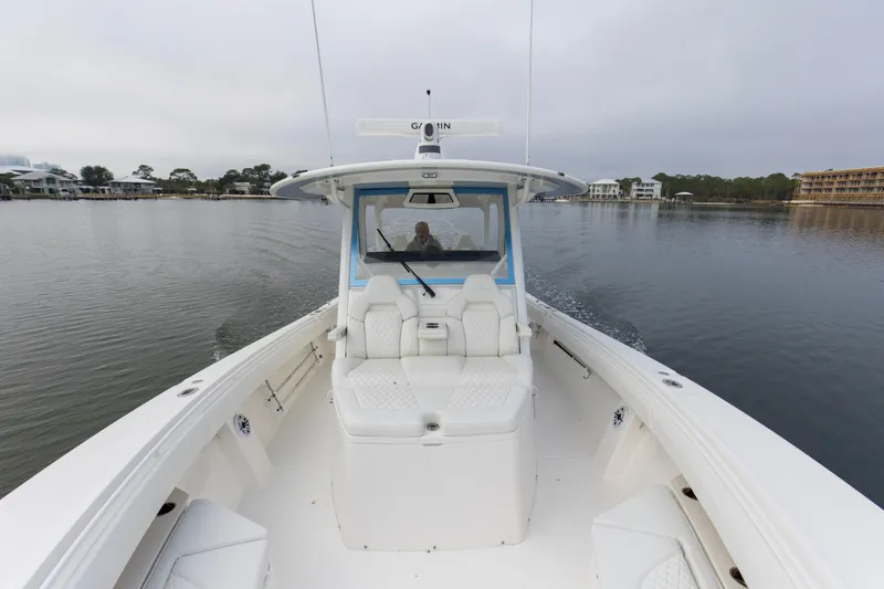 Slide: The Image of 2024 Regulator 37 boat cruising on calm waters, showcasing spacious deck and seating. - 9