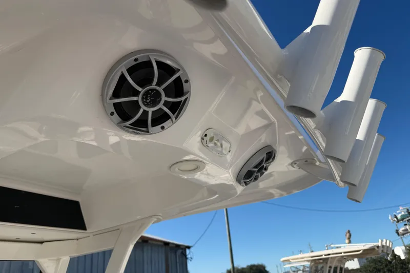Slide: The Image of 2022 Yamaha Boats 252 FSH Sport speakers and rod holders under clear blue sky. - 24
