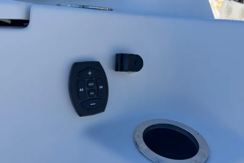Slide: The Image of Control panel on 2022 Yamaha Boats 252 FSH Sport, featuring audio controls and cup holder. - 35