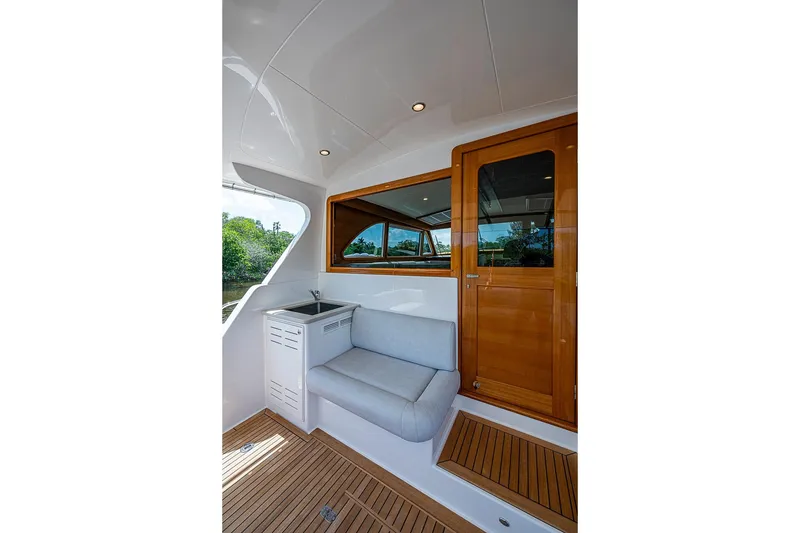 Slide: The Image of 2024 Grand Banks 44 Eastbay yacht interior with seating and wooden door. - 13