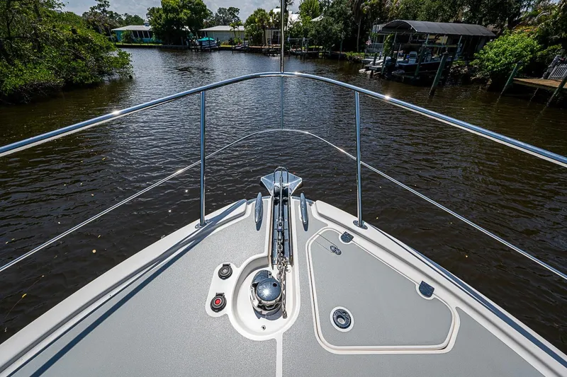 Slide: The Image of Bow view of 2024 Grand Banks 44 Eastbay yacht on a serene river. - 16