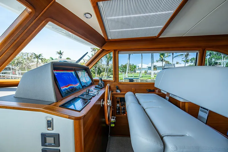 Slide: The Image of 2024 Grand Banks 44 Eastbay helm with modern navigation displays and luxurious seating. - 22