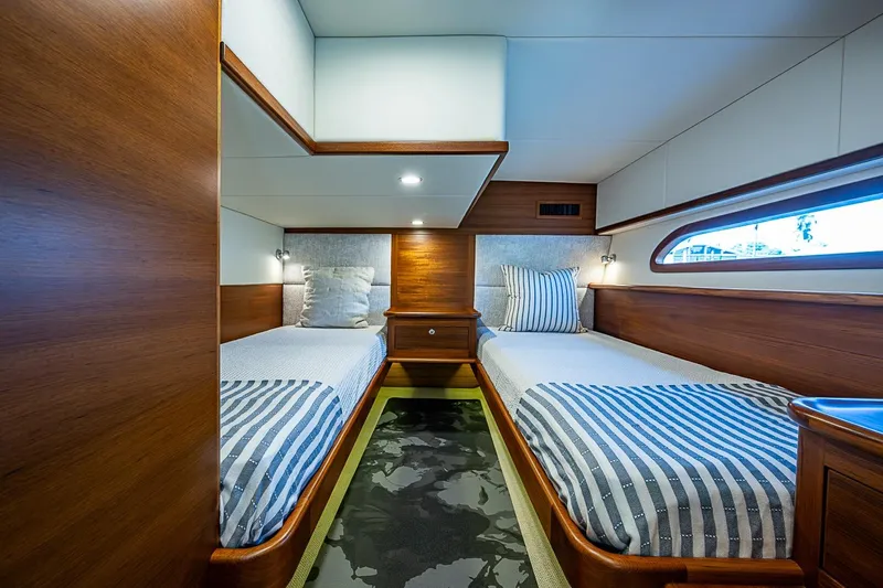 Slide: The Image of Luxurious twin cabin interior of 2024 Grand Banks 44 Eastbay yacht, featuring elegant wood finishes. - 30