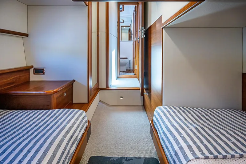 Slide: The Image of 2024 Grand Banks 44 Eastbay cabin with twin beds and elegant wood finish. - 32