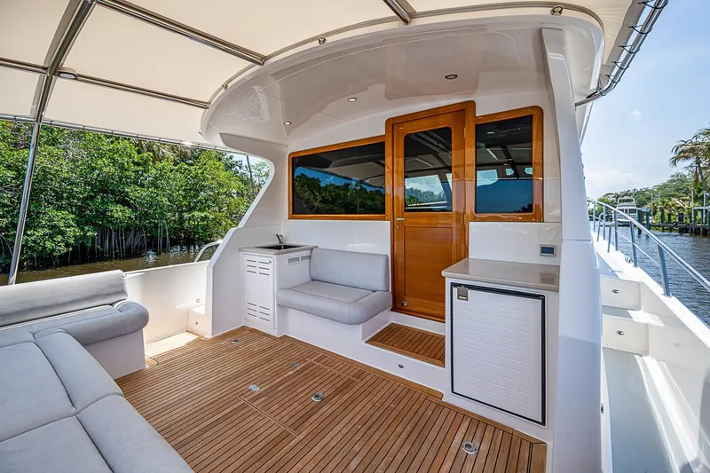 Slide: The Image of Luxurious 2024 Grand Banks 44 Eastbay yacht interior with teak flooring and comfortable seating. - 9