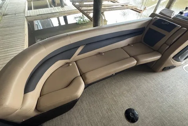 Slide: The Image of 2023 Barletta Cabrio 24CC boat interior with beige seating and carpeted floor. - 10