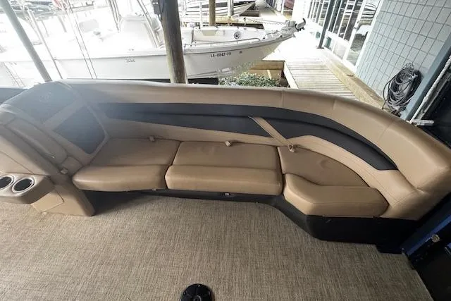 Slide: The Image of 2023 Barletta Cabrio 24CC boat interior with tan seating and cup holders. - 11