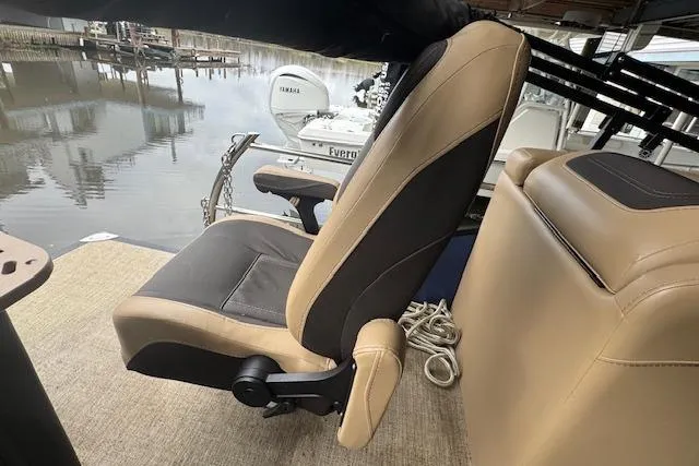 Slide: The Image of Captain's chair on 2023 Barletta Cabrio 24CC pontoon boat, docked by water. - 18