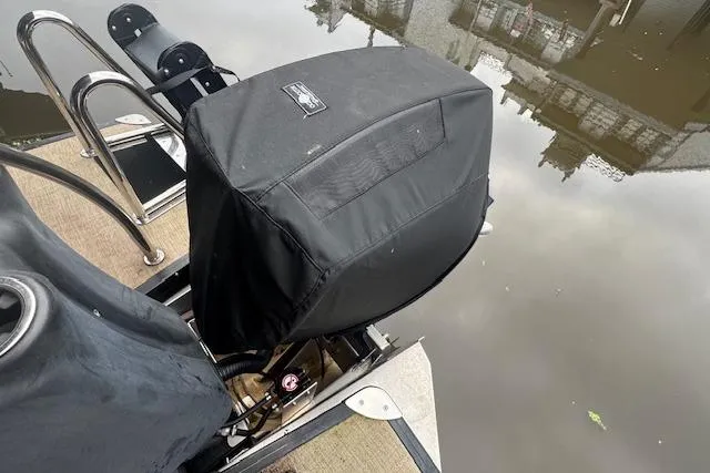 Slide: The Image of 2023 Barletta Cabrio 24CC boat engine covered, docked by calm water. - 22