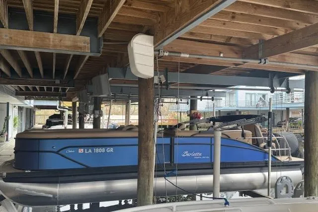 Slide: The Image of 2023 Barletta Cabrio 24CC pontoon boat docked under wooden shelter. - 3