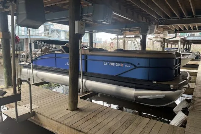 Slide: The Image of 2023 Barletta Cabrio 24CC pontoon boat docked in a covered marina. - 7