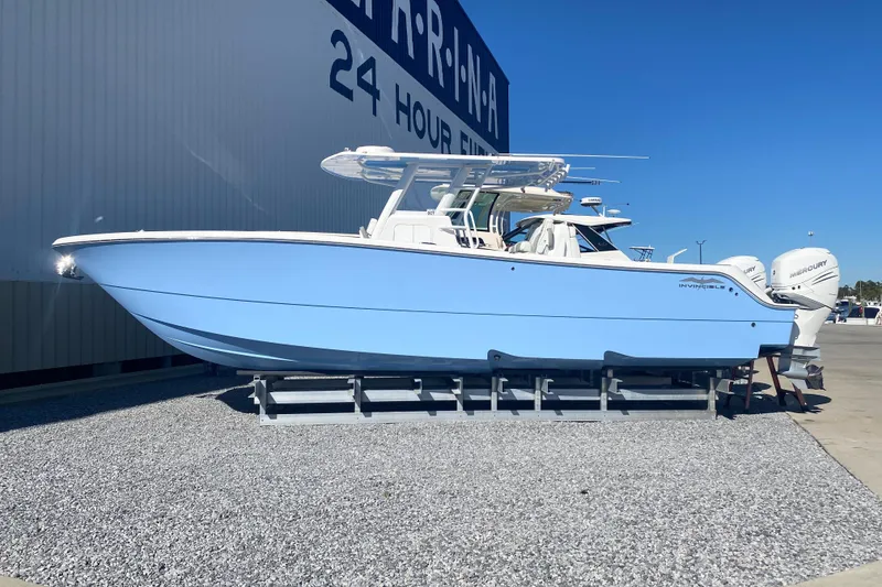 The Image of 2023 Invincible 33 Catamaran in light blue, displayed outdoors on gravel. - 1