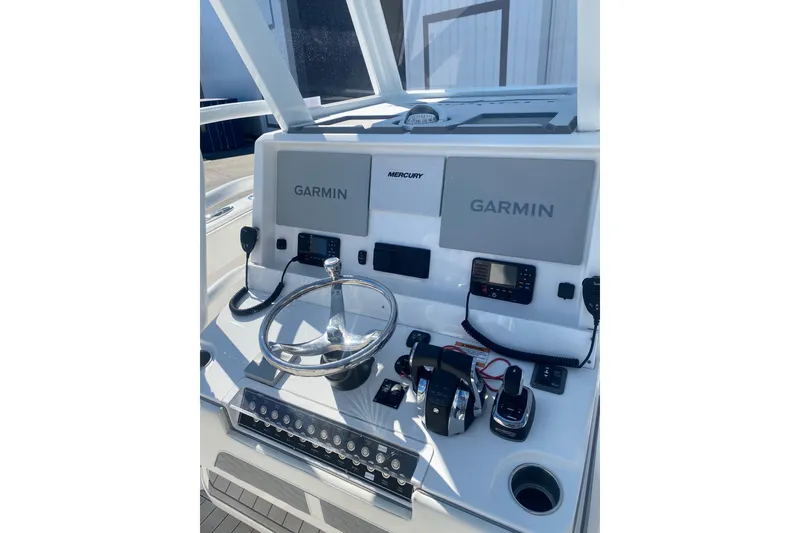 Slide: The Image of 2023 Invincible 33 Catamaran helm with Garmin displays and Mercury controls. - 13