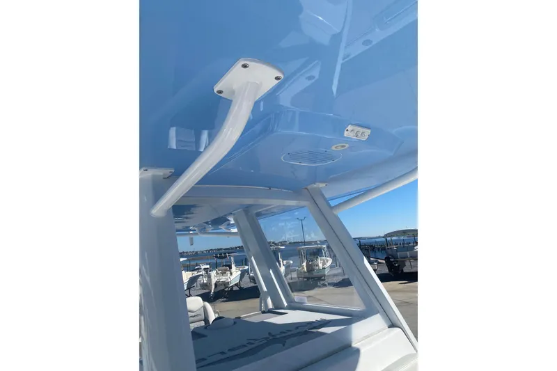 Slide: The Image of 2023 Invincible 33 Catamaran interior view with blue ceiling and marina background. - 16