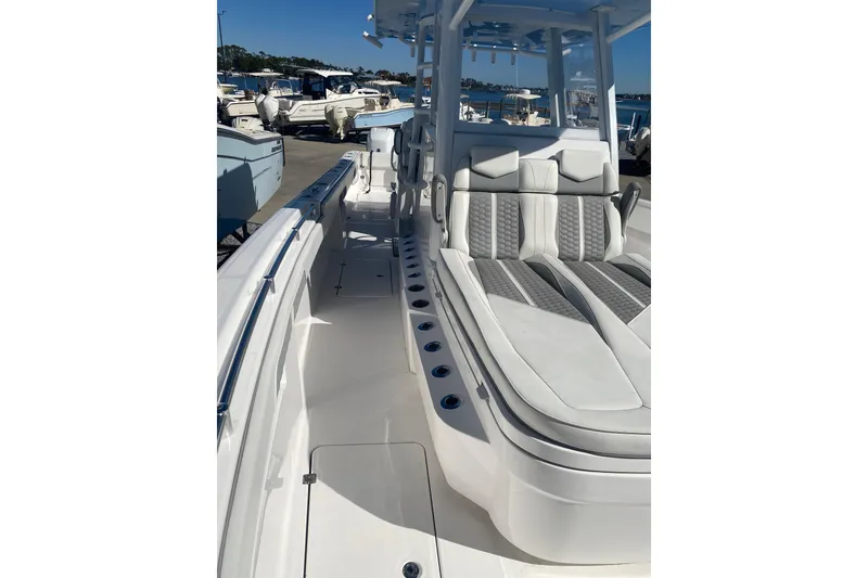 Slide: The Image of 2023 Invincible 33 Catamaran with sleek seating and modern design in a marina setting. - 17