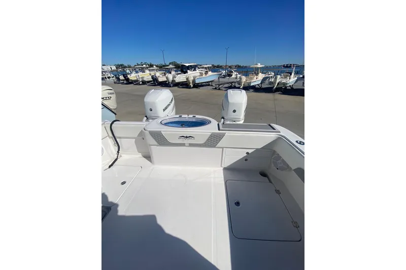 Slide: The Image of 2023 Invincible 33 Catamaran with dual Mercury engines, docked at a marina. - 7