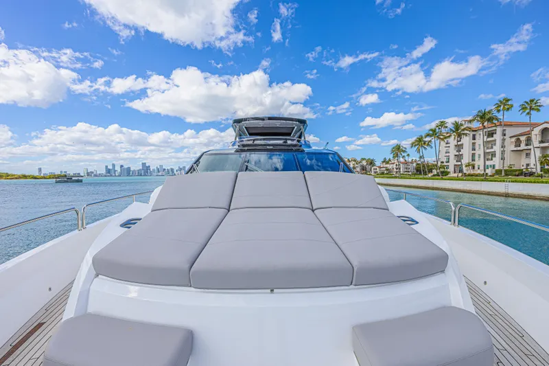Slide: The Image of 2025 Sunseeker 88 Yacht with luxurious sunbed, city skyline, and waterfront view. - 58