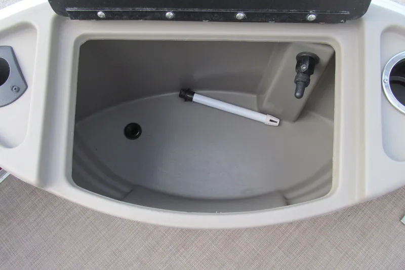 Slide: The Image of Storage compartment of 2023 Sun Tracker Bass Buggy 18 DLX boat, featuring a drain and cup holder. - 15