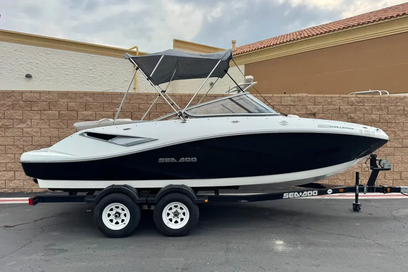 The Image of 2012 Bombardier Sea Doo 210 Challenger boat on trailer, parked outdoors. - 0