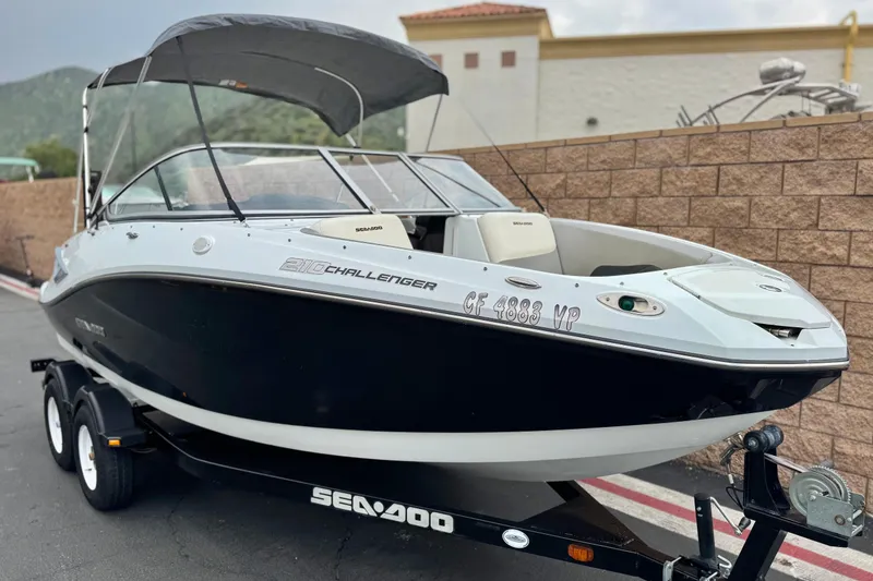 Slide: The Image of 2012 Bombardier Sea Doo 210 Challenger boat on trailer, parked outdoors. - 1