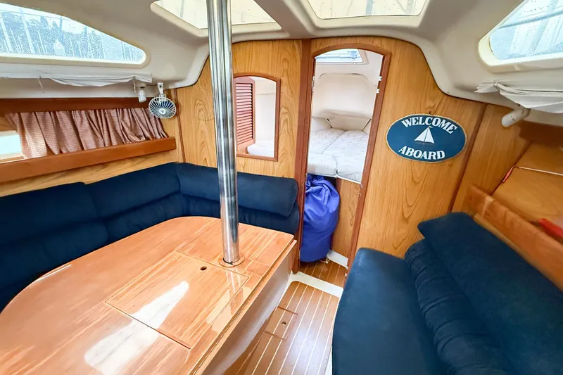 Slide: The Image of Interior of 2001 Hunter 340 sailboat with cozy seating and "Welcome Aboard" sign. - 10