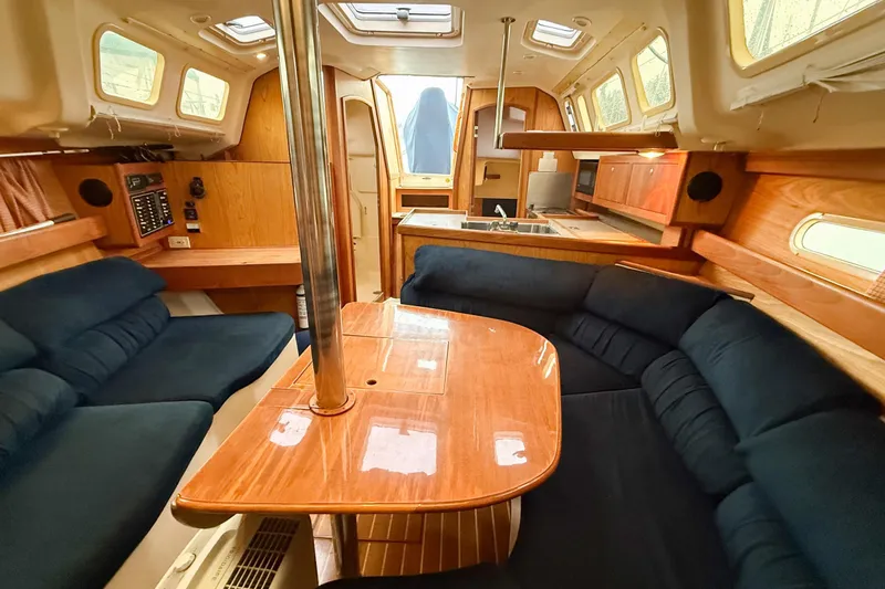 Slide: The Image of Interior of a 2001 Hunter 340 sailboat with wood finish and blue seating. - 11
