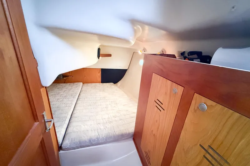 Slide: The Image of Interior cabin of a 2001 Hunter 340 sailboat with wooden cabinetry and a cozy bed. - 14