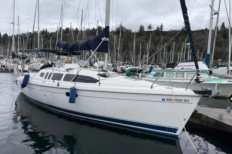 Slide: The Image of 2001 Hunter 340 sailboat docked in a marina, surrounded by other boats. - 26