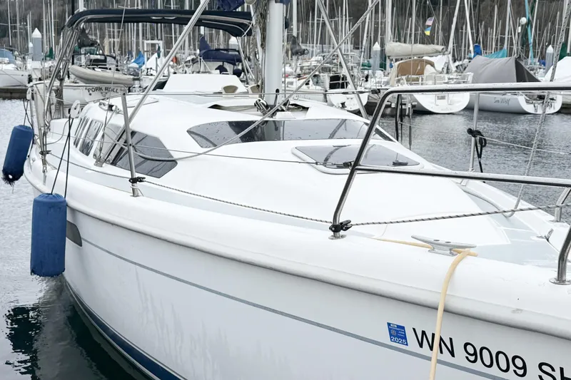 Slide: The Image of 2001 Hunter 340 sailboat docked in marina, featuring sleek design and white hull. - 27