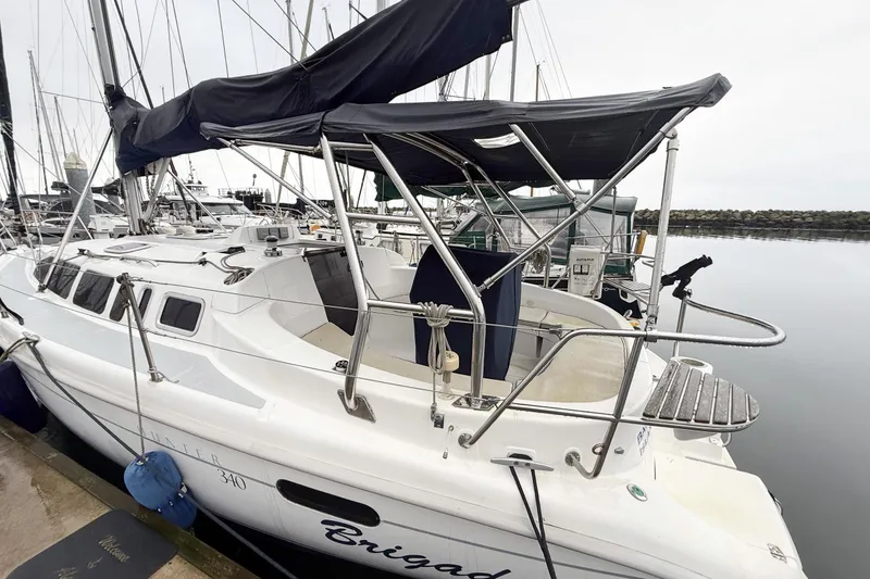 Slide: The Image of 2001 Hunter 340 sailboat docked at marina, featuring sleek design and covered cockpit. - 6