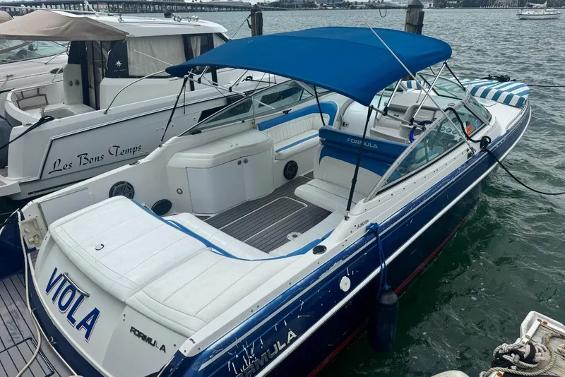 The Image of 1998 Formula 330 Sun Sport boat with blue canopy docked at marina. - 1
