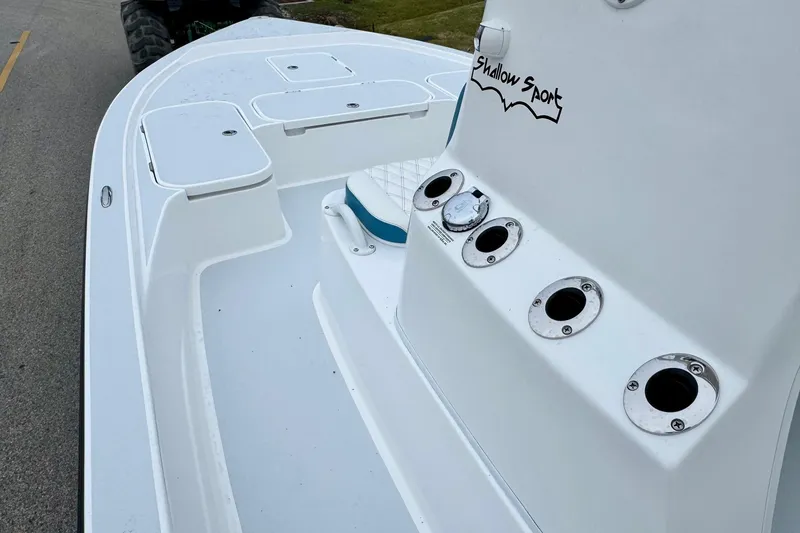 Slide: The Image of 2026 Shallow Sport 24 Modified V boat deck with rod holders and storage compartments. - 11