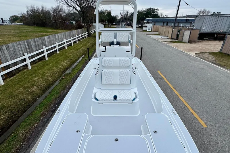 Slide: The Image of 2026 Shallow Sport 24 Modified V boat on a road, showcasing deck and seating. - 14