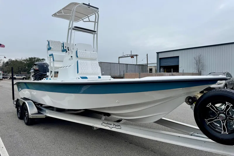 Slide: The Image of 2026 Shallow Sport 24 Modified V boat on trailer, parked outdoors. - 5