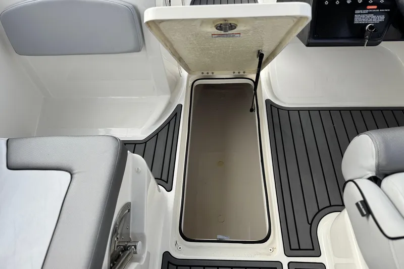 Slide: The Image of 2022 Bayliner VR5 Bowrider I/O interior storage compartment with open hatch and seating. - 24