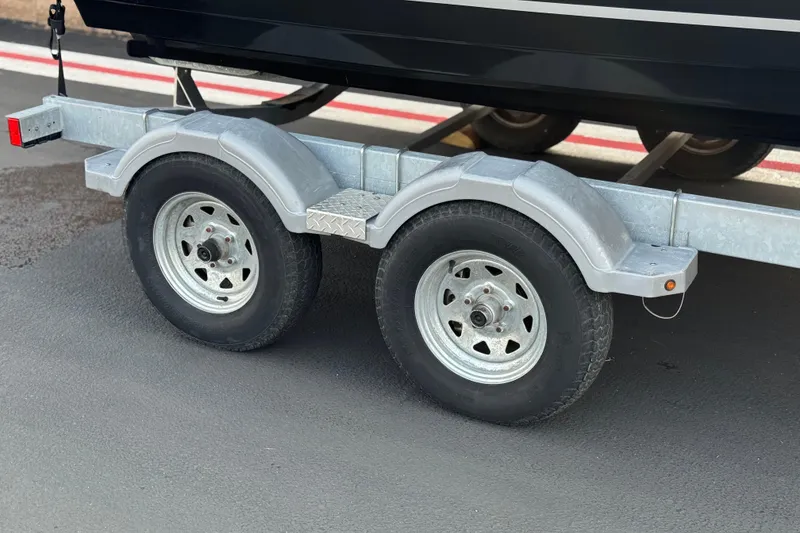 Slide: The Image of Trailer for 2022 Bayliner VR5 Bowrider I/O with dual wheels on pavement. - 32