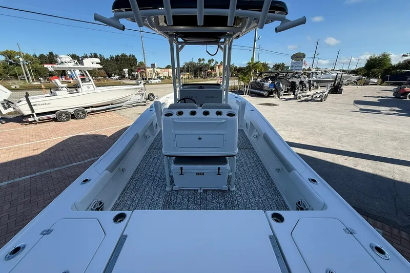 Slide: The Image of 2022 Caymas 28 HB Twin boat interior with console and seating, parked outdoors. - 13