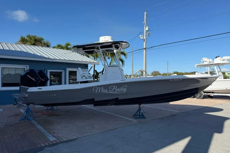 Slide: The Image of 2022 Caymas 28 HB Twin boat, gray hull, parked on a lot under clear blue sky. - 7